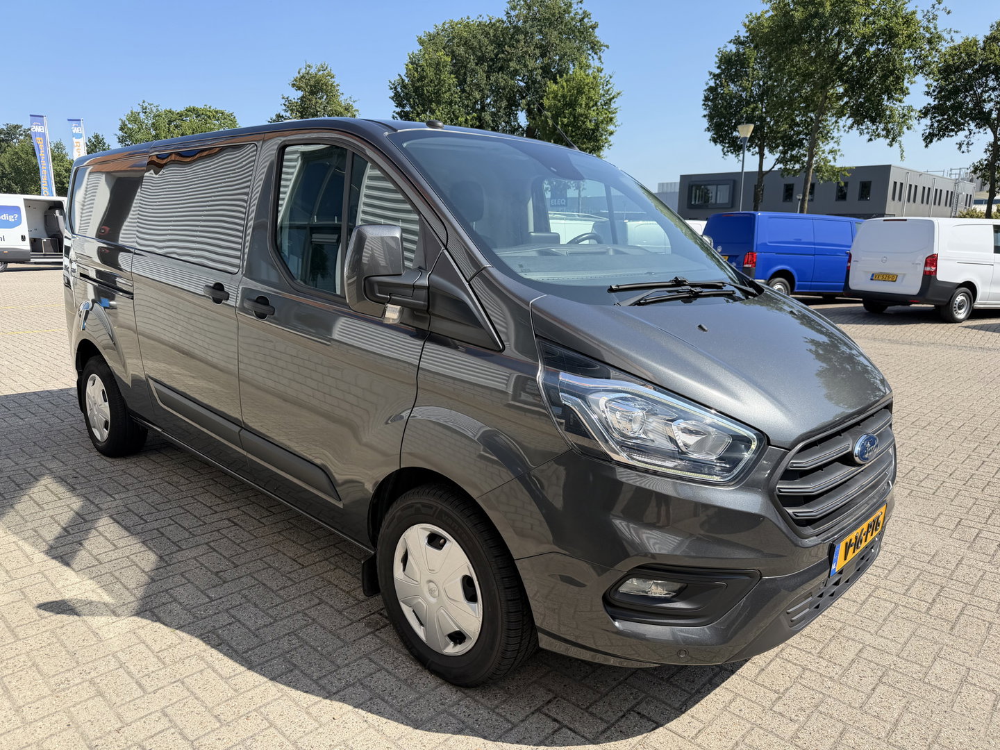 Ford Transit Custom 320 2.0 TDCI automaat L2H1 Trend / 3 persoons / vaste prijs rijklaar € 17.950 ex btw / lease vanaf € 302 / trekhaak / laadruimte gestoffeerd / airco / cruise / magneic grey metallic
