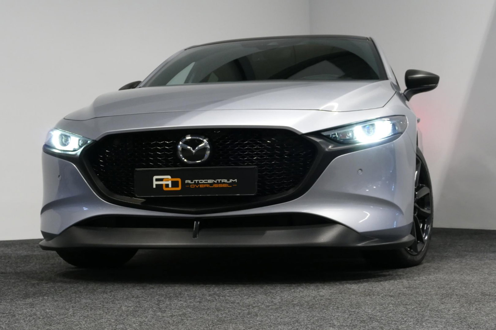 Mazda 3 2.0 e-SkyActiv-X M Hybrid 180 Luxury / Orig. Nederlands / Elektr. verstelbare voorstoel met memory / BOSE Audio / Apple Carplay - Android Auto / HUD / Stoelverwarming / Achteruitrijcamera / Cruise control / Dodehoekdetectie / Black Optic / 18'' LMV / Navi
