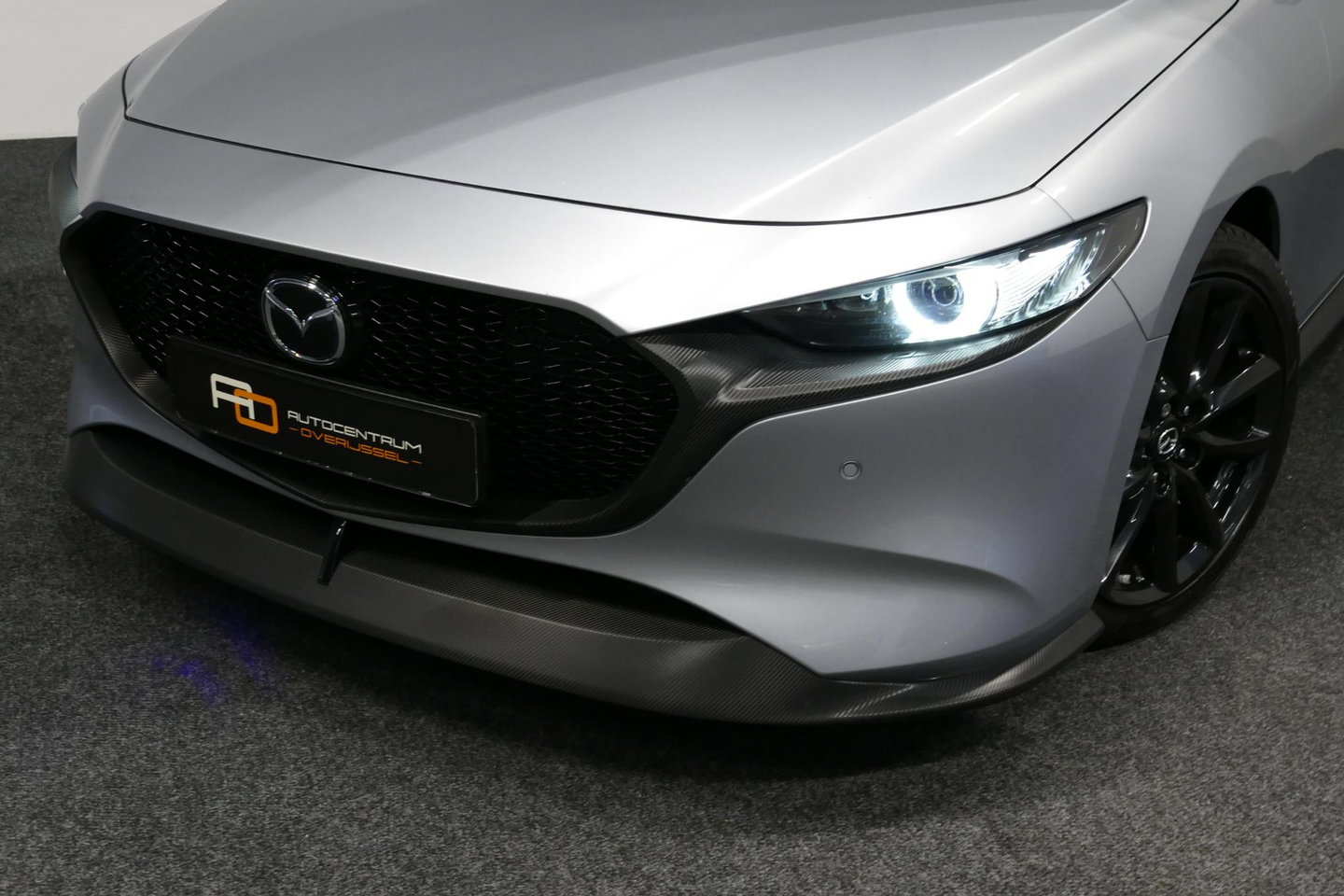 Mazda 3 2.0 e-SkyActiv-X M Hybrid 180 Luxury / Orig. Nederlands / Elektr. verstelbare voorstoel met memory / BOSE Audio / Apple Carplay - Android Auto / HUD / Stoelverwarming / Achteruitrijcamera / Cruise control / Dodehoekdetectie / Black Optic / 18'' LMV / Navi