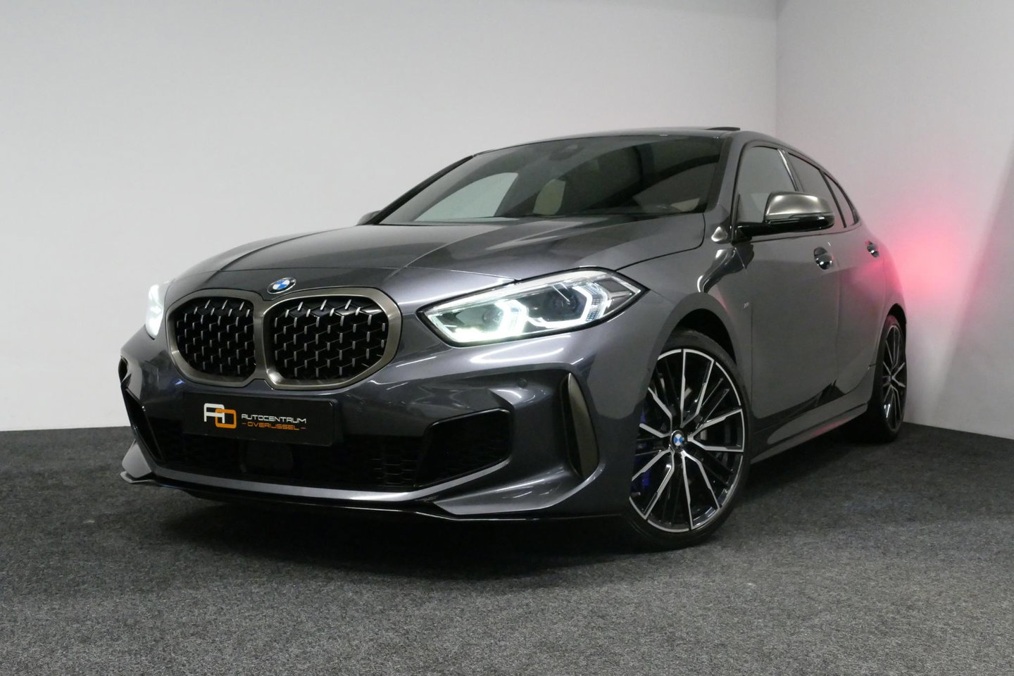 BMW 1 Serie M135i xDrive High Executive Edition / Orig. Nederlands / Panoramadak / Stoelverwarming / Apple Carplay - Android Auto / Ambienteverlichting / HUD / Achteruitrijcamera / Cruise Control / 19'' LMV / Spiegel-pakket / LED koplampen / Lederen bekleding