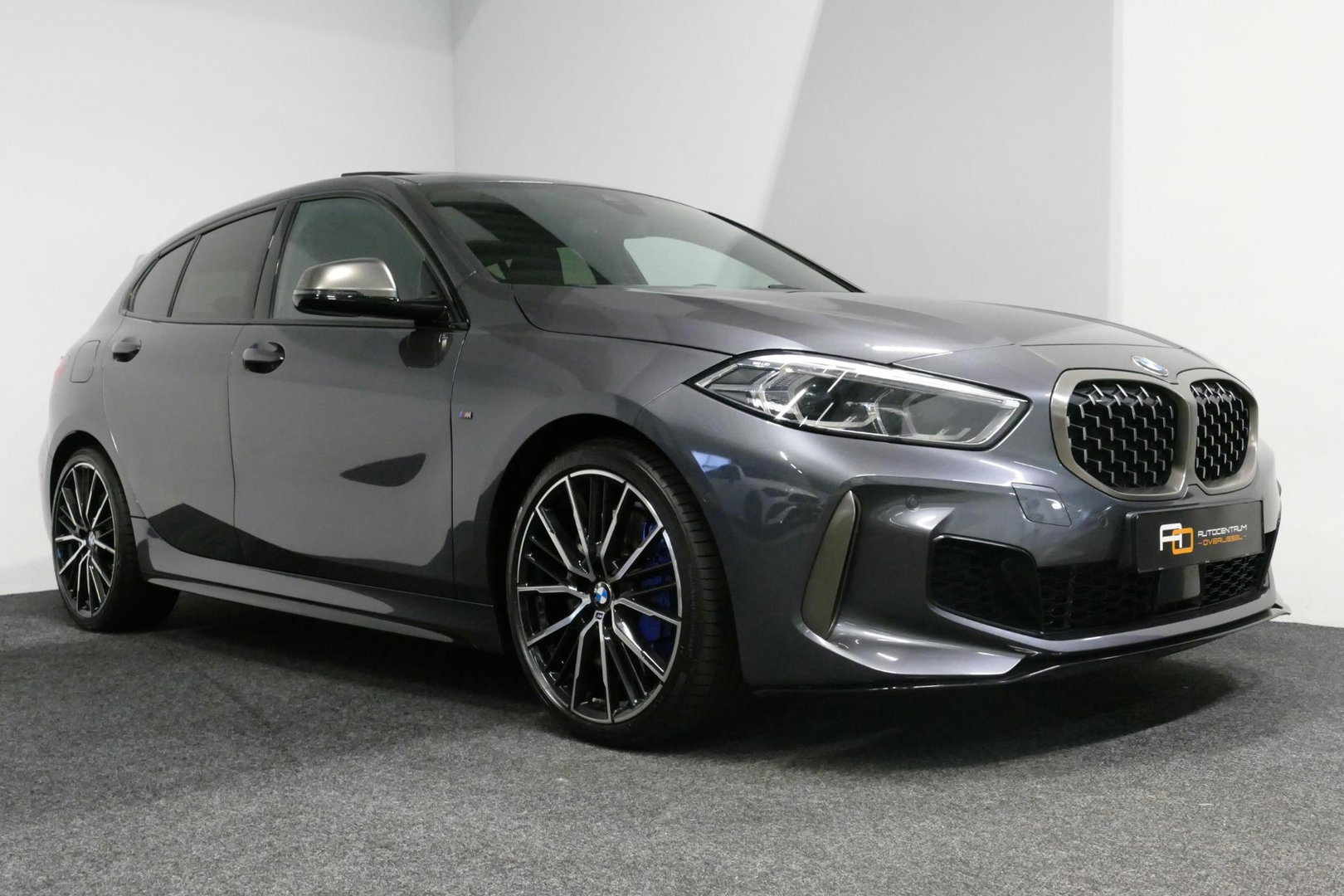 BMW 1 Serie M135i xDrive High Executive Edition / Orig. Nederlands / Panoramadak / Stoelverwarming / Apple Carplay - Android Auto / Ambienteverlichting / HUD / Achteruitrijcamera / Cruise Control / 19'' LMV / Spiegel-pakket / LED koplampen / Lederen bekleding